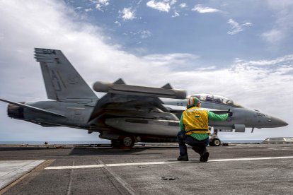 Un marinero da la señal para el lanzamiento de un E/A‑18 Growler.