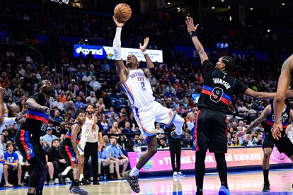 El base de los Oklahoma City Thunder, Shai Gilgeous-Alexander (2), lanza ante el alero-base de los Detroit Pistons, Ausar Thompson (9), durante la segunda parte de un partido de baloncesto de la NBA el lunes 30 de marzo de 2026 en Oklahoma City. (Foto AP/Gerald Leong)