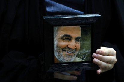 Un iraní sostiene un retrato del comandante asesinado de la Guardia Revolucionaria Qasem Soleimani