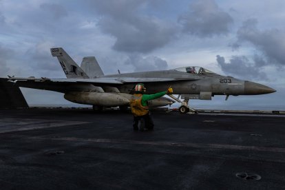 Un marinero estadounidense preparándose para lanzar un F/A-18E Super Hornet