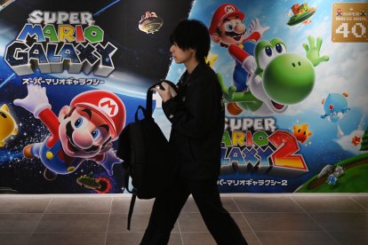 Un hombre pasa junto a carteles de Super Mario Galaxy en la tienda Nintendo de Tokio