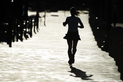 Una mujer corre por una calle de la ciudad haciendo ejercicios
