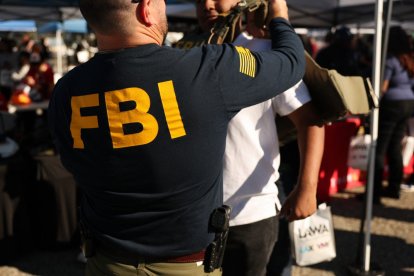 A student tries on a Federal Bureau of Investigation (FBI) vest while learning about jobs with the agency during the 10th annual Aviation Career Day at Los Angeles International Airport (LAX) in Los Angeles, California on October 30, 2025. (Photo by Patrick T. Fallon / AFP)