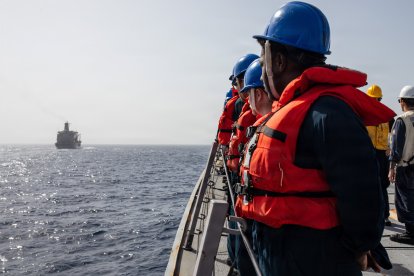 Marineros estadounidenses se apostan en las barandillas del destructor lanzamisiles de la clase Arleigh Burke USS Mitscher (DDG 57) durante una operación de reabastecimiento en el mar con el buque de reabastecimiento de la clase Henry J. Kaiser USNS Henry J. Kaiser (T-AO 187), en el marco de la Operación Epic Fury, el 3 de abril de 2026.
