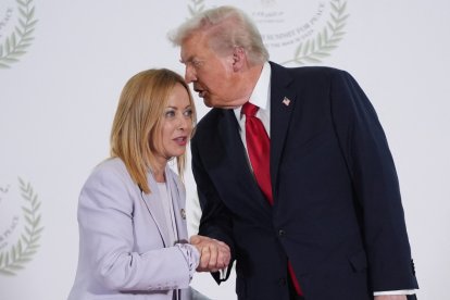 El presidente Trump dice algo al oído a la primer ministro de Italia Giorgia Meloni