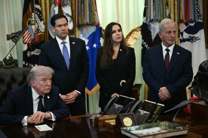 El presidente Trump y parte de su equipo escuchando a la prensa durante la reunión de hoy en la Casa Blanca.