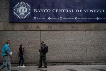 Varias personas caminan frente a la fachada principal del Banco Central de Venezuela en Caracas