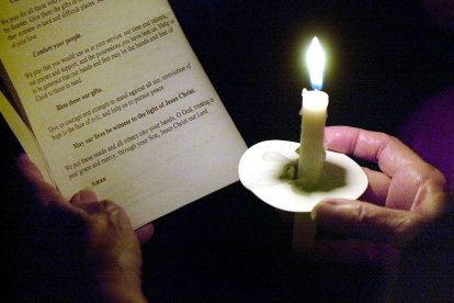 Un hombre sostiene una vela en la mano en una iglesia de Florida (Archivo)