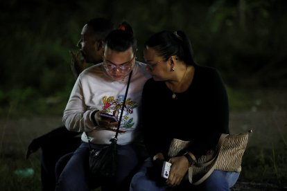 Dos mujeres hispanas con un celular en la mano (Archivo)