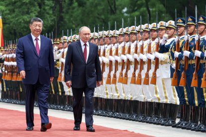 En esta fotografía de agencia distribuida por la agencia estatal rusa Sputnik, el presidente de Rusia, Vladímir Putin (centro), y el presidente de China, Xi Jinping (izquierda), pasan revista a la guardia de honor durante una ceremonia de bienvenida celebrada en el Gran Salón del Pueblo de Pekín el 20 de mayo de 2026. (Foto de Alexander KAZAKOV / POOL / AFP)