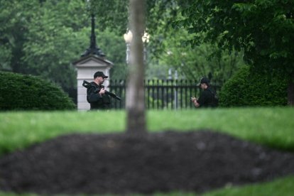 Un agente armado del Servicio Secreto reacciona en la Casa Blanca en Washington, DC, después de que aparentemente se escucharan disparos