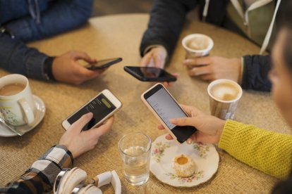 Adultos usando sus teléfonos móviles (Archivo)