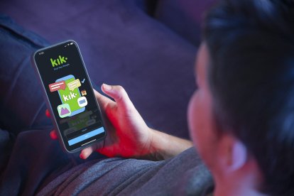 Un joven usando la plataforma de mensajería instantánea Kik.