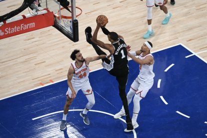El pívot-ala francés de los San Antonio Spurs, con el dorsal n.º 1, Victor Wembanyama, lanza a canasta mientras es defendido por el escolta de los Knicks, con el dorsal n.º 44, Landry Shamet, y el escolta de los Knicks, con el dorsal n.º 3, Josh Hart, durante el tercer partido de las Finales de la NBA entre los San Antonio Spurs y los New York Knicks, celebrado en el Madison Square Garden de Nueva York el 8 de junio de 2026.
