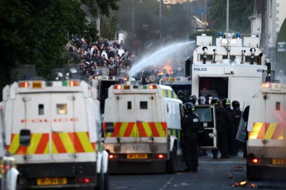 La policía utiliza un cañón de agua mientras bloquea el paso a los manifestantes en Glengormley, al norte de Belfast