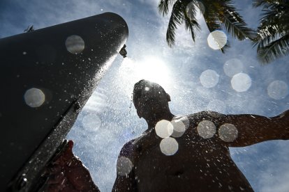 Un hombre se ducha en medio de una calurosa tarde en Miami Beach (Archivo)