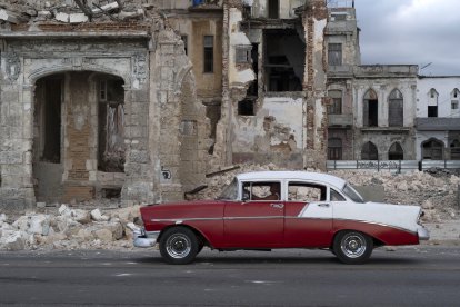 Un coche viejo pasa junto a los escombros de una casa en La Habana (Archivo)