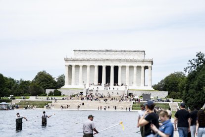 Trabajadores remueven las algas de la piscina reflectante del Memorial a Lincoln, este viernes 19 de junio.