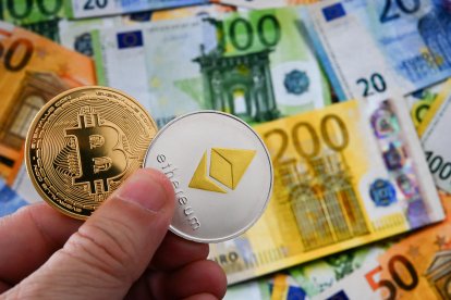 Ilustración de monedas de Bitcoin y Ethereum frente a diversos billetes de euro (Archivo)