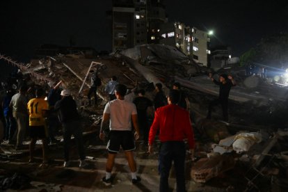 Personas de pie junto a un edificio derrumbado tras un terremoto en Caracas el 24 de junio de 2026.