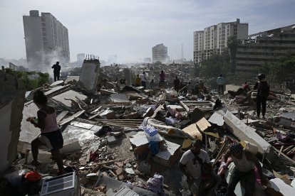 Habitantes locales caminan entre los escombros tras el doble terremoto que sacudió Caraballeda, estado de La Guaira, a unos 40 km al noreste de Caracas, el 25 de junio de 2026.