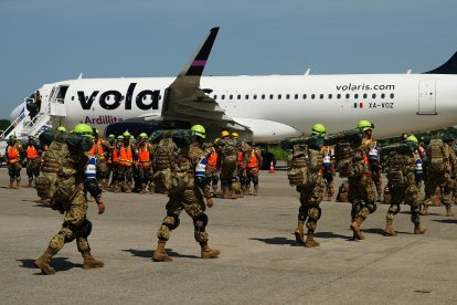 Soldados salvadoreños se preparan para abordar un avión con destino a Venezuela