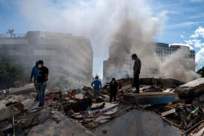 Rescuers and volunteers search for survivors in La Guaira, La Guaira state, Venezuela, on June 28, 2026, following twin earthquakes. Thousands of rescuers, relatives and volunteers dig day and night through mounds of concrete to find survivors of the earthquakes that struck Venezuela more than three days ago, leaving nearly 1,500 dead and tens of thousands missing. (Photo by Miguel MEDINA / POOL / AFP)