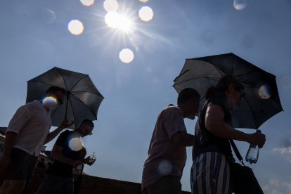 Personas se resguardan del sol bajo en Varsovia.