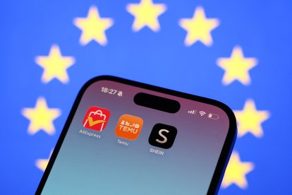 Una bandera de la Unión Europea detrás de las aplicaciones de AliExpress, Temu y Shein
