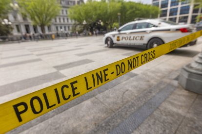 Police car vehicle of United States Secret Service and POLICE LINE- DO NOT CROSS ribbon.