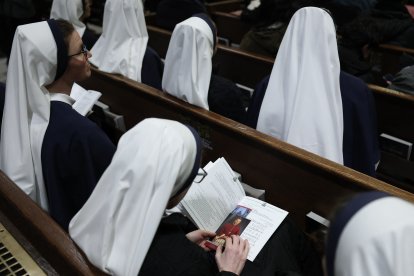 A nun looks through the program of the Solemn Vespers evening prayer at St. Patrick's Cathedral in New York