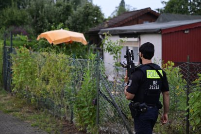 Un agente de policía armado con un arma automática camina por un complejo de huertos urbanos en el barrio de Spandau, al oeste de Berlín, el 26 de julio de 2026, en una zona ajardinada cercana al lugar donde el principal sospechoso del ataque mortal de la noche anterior, ocurrido cerca del desfile del Orgullo de Berlín, fue abatido a tiros. La policía alemana buscó el 26 de julio de 2026 a un sospechoso que se cree que está vinculado a círculos islamistas después de que un coche arrollara a una multitud cerca de las celebraciones del Orgullo Gay de Berlín, matando a una persona e hiriendo a otras 29. El incidente truncó lo que había sido un día de celebración para los cientos de miles de asistentes al Christopher Street Day, uno de los eventos del Orgullo más grandes de Europa, y provocó que los asistentes huyeran de un parque del centro de Berlín mientras las sirenas resonaban en la noche.
*** Translated with www.DeepL.com/Translator (free version) ***
