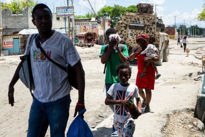 Una familia huye de un barrio tras los disturbios de pandillas ocurridos la noche anterior en Puerto Príncipe, el 20 de abril de 2026.