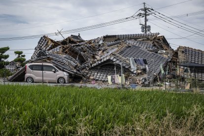 En la imagen se ve una casa derrumbada sobre un coche en Hikawa, en la prefectura de Kumamoto, el 30 de julio de 2026, tras el terremoto que sacudió la zona. El centro comercial Aeon de Kumamoto acababa de reabrir sus puertas en junio, reluciente, más resistente y seguro gracias a las últimas reformas realizadas tras los terremotos de 2016, con la promesa de ser un lugar donde las generaciones pudieran «compartir sonrisas». Sin embargo, a pesar de las exhaustivas obras de refuerzo realizadas en las instalaciones, que sufrieron graves daños hace una década, una explosión provocada por un nuevo terremoto el 28 de julio en la región suroeste de Japón las ha dejado en ruinas.