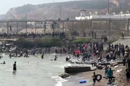 Esta captura de vídeo de AFP muestra a migrantes llegando a la costa del enclave español de Ceuta, en el norte de África, tras nadar alrededor de la valla fronteriza entre Marruecos y España, en Ceuta, el 30 de julio de 2026.