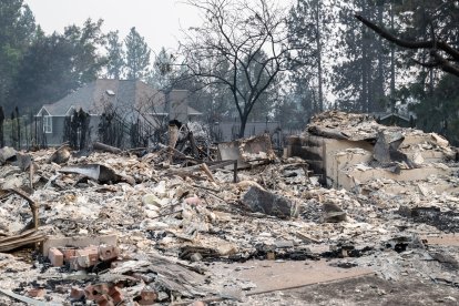 Los escombros de una vivienda residencial calcinada siguen ardiendo lentamente en el barrio de Balboa, en Spokane (Washington), el 2 de agosto de 2026. Los incendios, que avanzaron a gran velocidad, dejaron un rastro de destrucción el domingo en la ciudad de Spokane, situada en el noroeste de Estados Unidos, y las autoridades informaron de que cientos de edificios quedaron reducidos a cenizas.