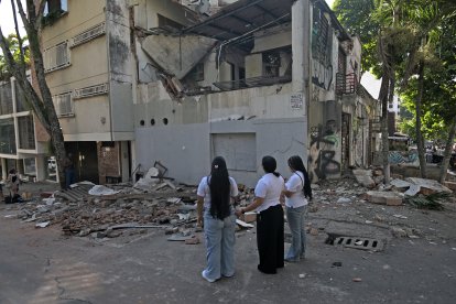Mujeres miran un edificio caído tras el sismo en Colombia