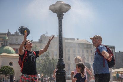 Personas se refrescan en medio de una ciudad por las altas temperaturas (Archivo)
