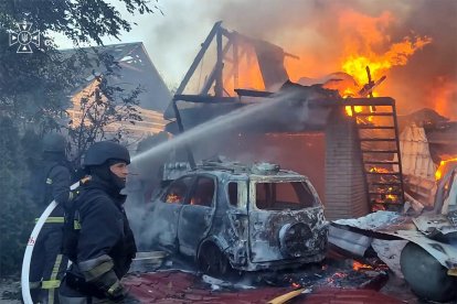 Rescatistas ucranianos trabajando para extinguir un incendio en una casa tras un ataque aéreo