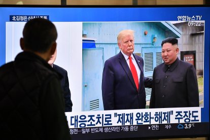 Un hombre observa por televisión la reunión entre Donald Trump y Kim Jong Un, el 1 de enero de 2020.