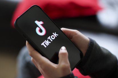 Una niña sostiene un iPhone 16 con el logotipo de la aplicación TikTok/ Jan Woitas