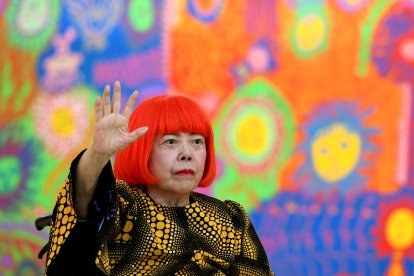 La artista japonesa Yayoi Kusama saluda durante una sesión fotográfica (Archivo)