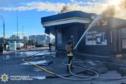 Un policía extinguiendo un incendio en una gasolinera dañada tras un ataque con drones rusos en Kiev