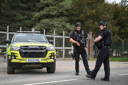 Agentes de policía armados montan guardia en un control de carretera situado en una de las entradas de la base de la RAF Fairford, en Fairford, al suroeste de Inglaterra, el 27 de septiembre de 2026, mientras la policía antiterrorista del Reino Unido investiga un incidente ocurrido cerca de la base, en la localidad de Whelford. El 27 de septiembre, la policía británica declaró un incidente grave y evacuó a los vecinos que vivían cerca de una base utilizada por la Fuerza Aérea de los Estados Unidos tras detener a varios hombres como sospechosos de delitos relacionados con explosivos.