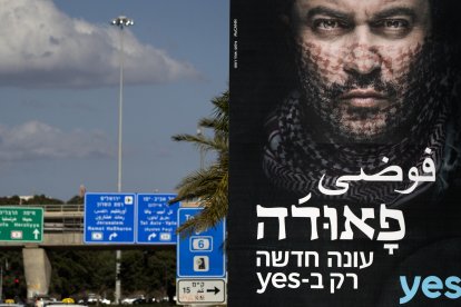 Una fotografía tomada el 31 de diciembre de 2017 en la ciudad israelí de Tel Aviv muestra una valla publicitaria con texto en árabe y hebreo que promociona la nueva temporada de la exitosa serie de televisión israelí «Fauda». La segunda temporada de «Fauda», una exitosa serie de televisión israelí cuyo estreno está previsto para más tarde esta noche, ha provocado una protesta pública por parte de los vecinos, que se sienten intimidados por los carteles. La aclamada serie de ficción profundiza en las complejidades del conflicto israelo-palestino a través de la historia de una unidad de agentes encubiertos.
