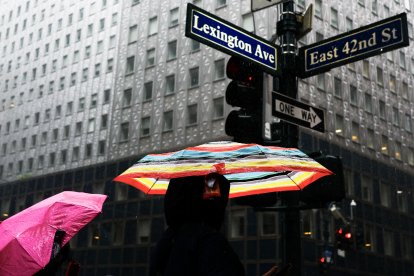Varias personas caminan bajo la lluvia cerca de la terminal Grand Central en Nueva York