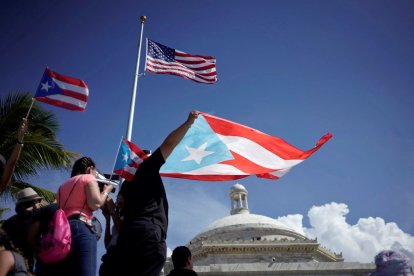 Imagen de archivo y de referencia que muestran manifestantes con la bandera de Puerto Rico
