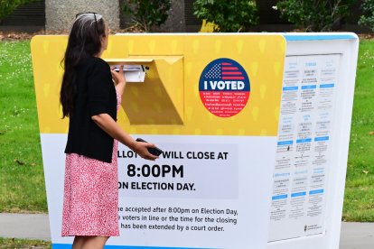 Un votante deposita su boleta en un buzón electoral durante la votación anticipada (Archivo)