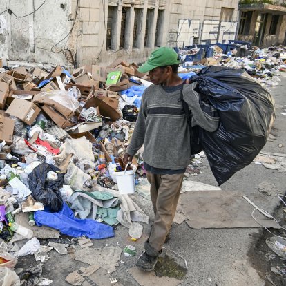 Un hombre camina por una calle de La Habana convertida en basurero