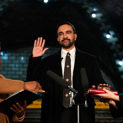 New York mayor-elect Zohran Mamdani (C) places his hand on a Quran